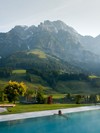 Person im Infinity Pool des Heaven Spa mit Bergpanorama am Morgen – Naturresort Puradies, Leogang, Salzburger Land Person im Infinity Pool des Heaven Spa mit Bergblick, Puradies Leogang