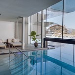Indoor pool at Heaven Spa with view of Traumquartier in winter, Puradies Leogang