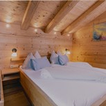 Schlafzimmer mit Holzbett im Chalet, Puradies Leogang