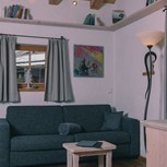 Wohnbereich mit Sofa und Bücherregal im Chalet, Puradies Leogang