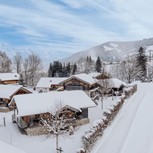 Verschneites Chaletdorf mit Bergpanorama, Naturresort Puradies