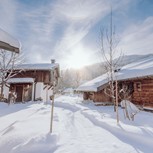 Verschneite Chalets im Winter bei Sonnenschein, Puradies Leogang