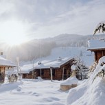 Verschneiter Weg zwischen Chalets bei Sonnenschein, Puradies Leogang