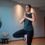 Yogalehrerin Sabrina im Einbeinstand mit gefalteten Händen, Puradies Leogang