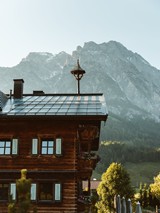 Embachhof mit Dachturm vor Bergpanorama, Puradies Leogang