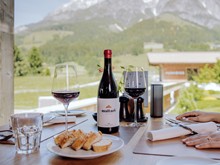 Tisch mit Rotwein und Bergpanorama, Naturresort Puradies