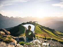 Wanderin bei Sonnenaufgang am Großen Asitz, Naturresort Puradies in Leogang