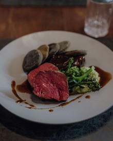 Rosa gebratenes Fleisch mit Brokkoli auf weißem Teller, Puradies Leogang