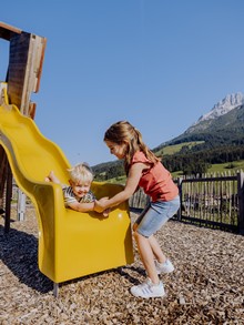 Kinder an gelber Rutsche am Spielplatz, Puradies Leogang