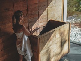 Person bereitet den Aufguss am Saunaofen vor im Heaven Spa – Naturresort Puradies, Leogang, Salzburger Land Person bereitet Aufguss am Saunaofen vor, Puradies Leogang