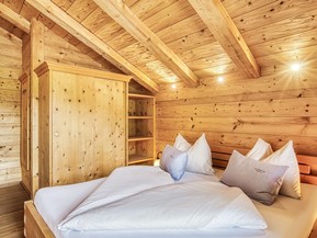 Schlafzimmer mit Holzschrank im Privat Spa Chalet Premium im Naturresort Puradies Schlafzimmer mit Holzschrank im Privat Spa Chalet Premium im Naturresort Puradies