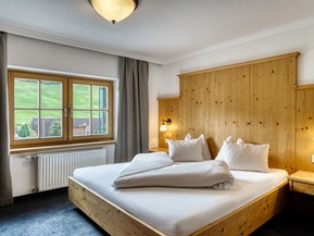 Doppelbett mit Holzverkleidung im Genießerzimmer im Naturresort Puradies