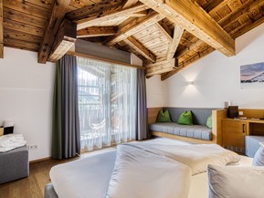 Doppelbett mit Sitzbank und Balkonzugang im Natur Loft im Naturresort Puradies