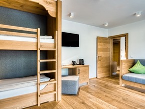 Zusätzlicher Wohnbereich mit Etagenbett und Sofa in der Premium Suite im Naturresort Puradies