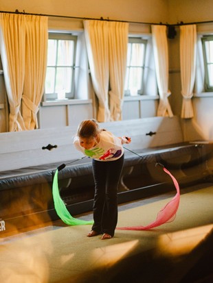 Child Performing with Movement Ribbons in the Event Chalet During Circus Week at Naturresort Puradies, Leogang, Salzburger Land Child performing with movement ribbons, Puradies Leogang