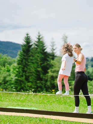 Balancing on the Slackline Beam During Circus Week at Naturresort Puradies, Leogang, Salzburger Land Child balancing on slackline beam, Puradies Leogang