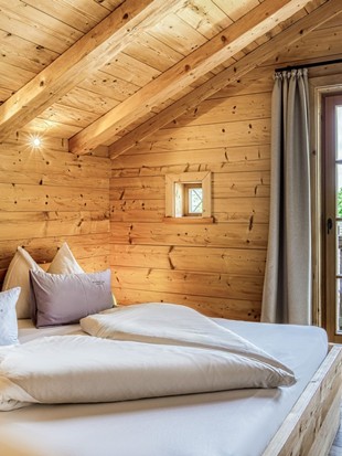 Schlafzimmer mit Balkonzugang im Privat Spa Chalet Premium im Naturresort Puradies Schlafzimmer mit Balkonzugang im Privat Spa Chalet Premium im Naturresort Puradies