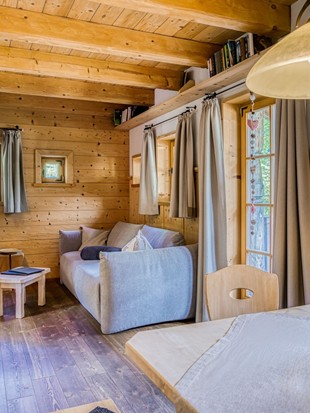 Wohnbereich mit Sofa und Esstisch im Privat Spa Chalet Premium im Naturresort Puradies Wohnbereich mit Sofa und Esstisch im Privat Spa Chalet Premium im Naturresort Puradies