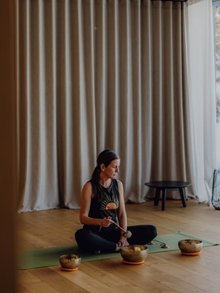 Yoga Instructor Sabrina during Sound Bowl Meditation in the Yoga Studio – Naturresort Puradies, Leogang, Salzburger Land Yoga instructor Sabrina during sound bowl meditation, Naturresort Puradies in Leogang