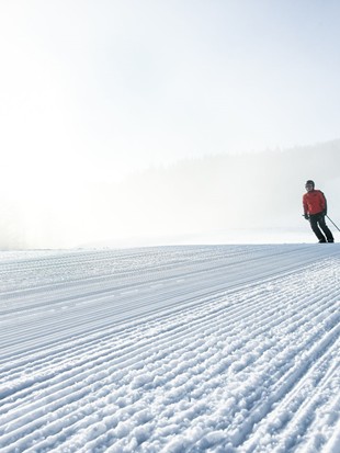 Skifahrer auf frisch präparierter Piste, Naturresort Puradies in Leogang