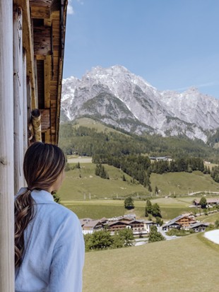 Person im Bademantel mit Bergblick im Naturresort Puradies Person im Bademantel mit Bergblick im Naturresort Puradies