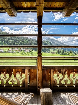 Balkon mit Liegestühlen und Ausblick auf Leogang der Deluxe Suite im Naturresort Puradies