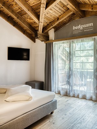 Doppelbett mit Fernseher und Balkonzugang im Familien Loft im Naturresort Puradies Doppelbett mit Fernseher und Balkonzugang im Familien Loft im Naturresort Puradies