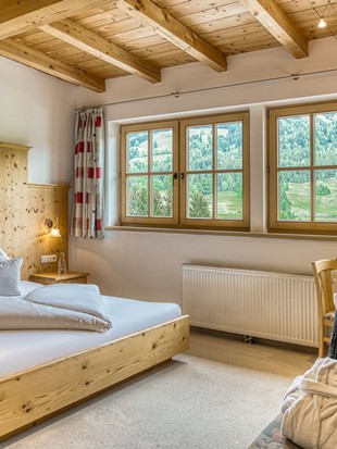 Doppelbett mit Panoramafenster im Genießerzimmer im Naturresort Puradies