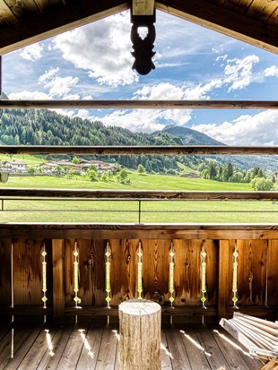 Balkon mit Liegestuhl und Ausblick auf Leogang im Natur Loft im Naturresort Puradies