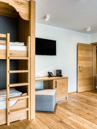 Zusätzlicher Wohnbereich mit Etagenbett und Sofa in der Premium Suite im Naturresort Puradies