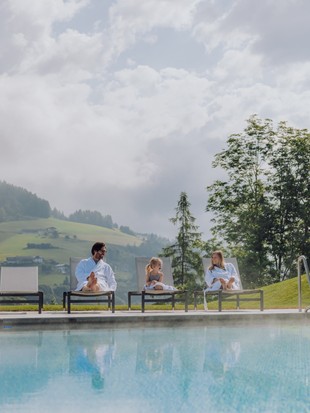 Familie im Bademantel am Infinity Pool im Sommer, Naturresort Puradies, Leogang, Salzburger Land Familie im Bademantel am Infinity Pool im Sommer, Puradies Leogang