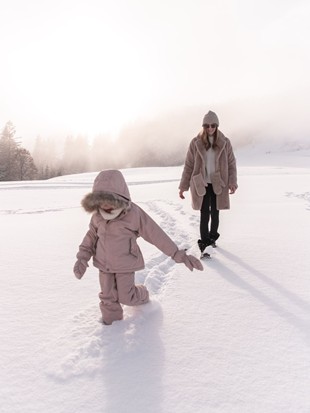 Person and Child on a Winter Walk in the Snow near Naturresort Puradies Person and child on a winter walk in the snow near Naturresort Puradies