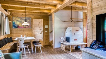 Wohn- und Essbereich mit Kachelofen im Privat Spa Chalet Premium im Naturresort Puradies Wohn- und Essbereich mit Kachelofen im Privat Spa Chalet Premium im Naturresort Puradies