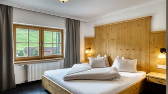 Doppelbett mit Holzverkleidung im Genießerzimmer im Naturresort Puradies Doppelbett mit Holzverkleidung im Genießerzimmer im Naturresort Puradies