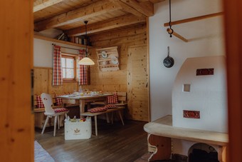 Gedeckter Frühstückstisch mit Kachelofen im Chalet, Puradies Leogang