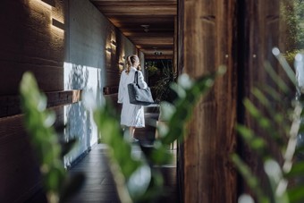 Person im Bademantel im Gang zum Adults-Only Saunahaus, Heaven Spa – Naturresort Puradies, Leogang, Salzburger Land Person im Bademantel im Gang zum Saunahaus, Puradies Leogang