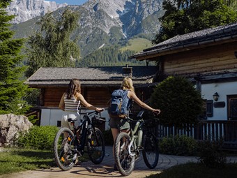 Zwei Mountainbikerinnen im Chaletdorf – Naturresort Puradies, Leogang, Salzburger Land Zwei Mountainbikerinnen im Chaletdorf, Naturresort Puradies in Leogang