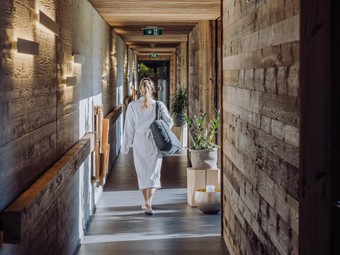 Person im Bademantel im Gang zum Adults-Only Saunahaus, Heaven Spa – Naturresort Puradies, Leogang, Salzburger Land Person im Bademantel im Gang zum Saunahaus, Puradies Leogang