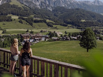 Zwei Wanderinnen an Aussichtsplattform mit Blick auf Hotel, Naturresort Puradies in Leogang