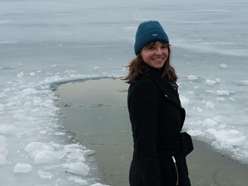 Edith Aigner lächelnd vor einer Eisbadestelle im zugefrorenen Wasser – Retreat, Naturresort Puradies, Leogang, Salzburger Land Edith Aigner vor Eisbadestelle im zugefrorenen Wasser, Retreat Puradies Leogang
