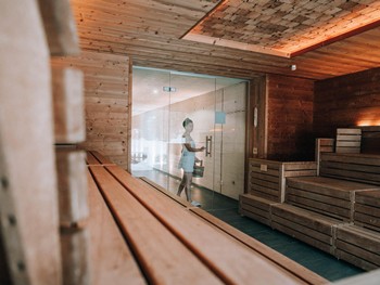 Person betritt die Sauna mit Holzeimer im Heaven Spa – Naturresort Puradies, Leogang, Salzburger Land Person mit Holzeimer betritt die Sauna, Puradies Leogang