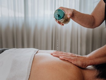Rückenmassage mit Öl im Heaven Spa, Naturresort Puradies, Leogang, Salzburger Land Massageöl wird auf den Rücken aufgetragen, Heaven Spa, Puradies Leogang