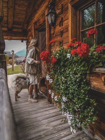 Person with a Dog at the Entrance of a Chalet at Naturresort Puradies Person with a dog at the entrance of a chalet at Naturresort Puradies