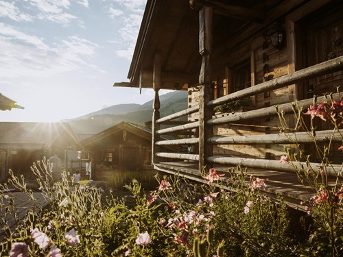 Chalets im Sommerlicht mit blühenden Blumen, Naturresort Puradies, Leogang Chalets im Sommerlicht mit blühenden Blumen, Puradies Leogang