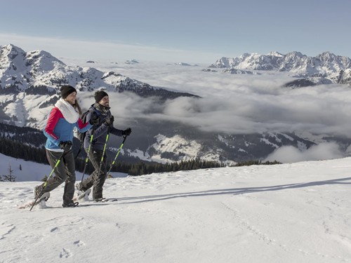 Zwei Personen bei Schneeschuhwanderung über Wolkenmeer, Naturresort Puradies
