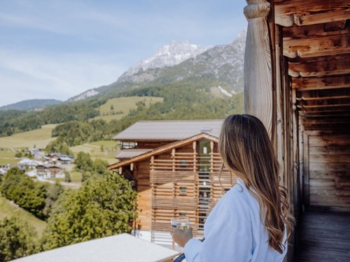 Person im Bademantel auf dem Balkon mit Bergblick, Naturresort Puradies, Leogang, Salzburger Land Person im Bademantel auf Balkon mit Bergblick, Puradies Leogang