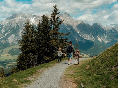 Father Hiking with Two Children on a Mountain Trail – Naturresort Puradies in Leogang, Salzburger Land Father hiking with two children on a mountain trail at Naturresort Puradies in Leogang