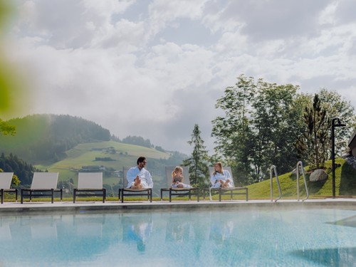 Familie im Bademantel am Infinity Pool im Sommer, Puradies Leogang