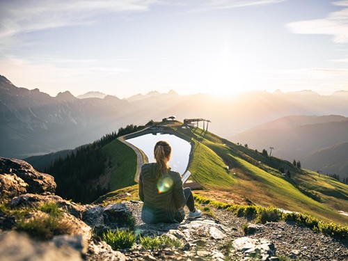 Wanderin bei Sonnenaufgang am Großen Asitz – Naturresort Puradies, Leogang, Salzburger Land Wanderin bei Sonnenaufgang am Großen Asitz, Naturresort Puradies in Leogang