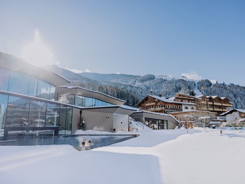 Personen im beheizten Infinity Pool des Heaven Spa im Winter – Naturresort Puradies, Leogang, Salzburger Land Personen im beheizten Infinity Pool im Winter, Puradies Leogang